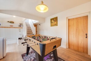 A cozy room with a foosball table, a staircase, and a wooden door. - 4 Bed in Westleton (oc-holc) (Westleton)