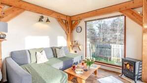 En hyggelig stue med sofa, sofabord og pejs.