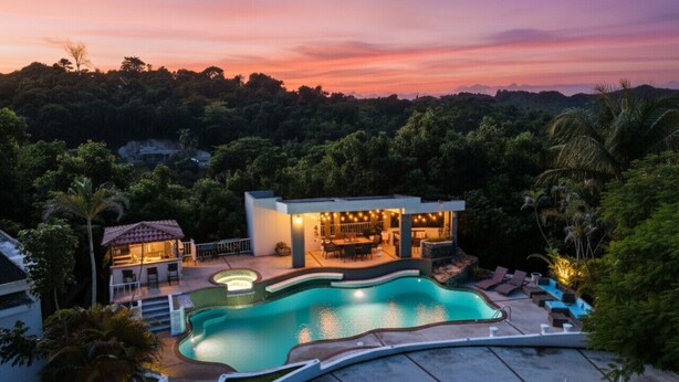 Una casa moderna con piscina, zona de comedor exterior y barra.