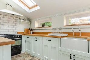 A kitchen with white cabinets, a black stove, a wooden countertop, and a skylight. - 2 Bed in Holt (oc-1863) (Holt)