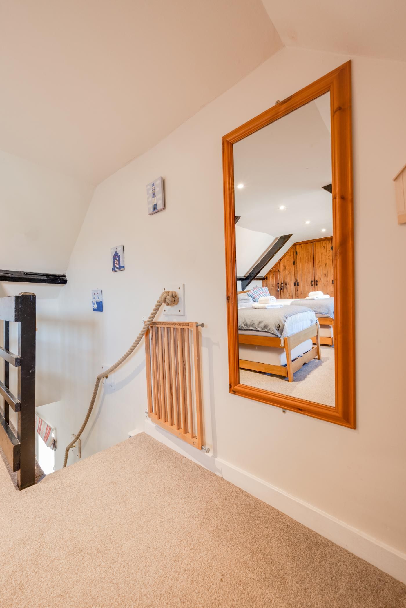 A bedroom with a large mirror, wooden bed frames, and a radiator.