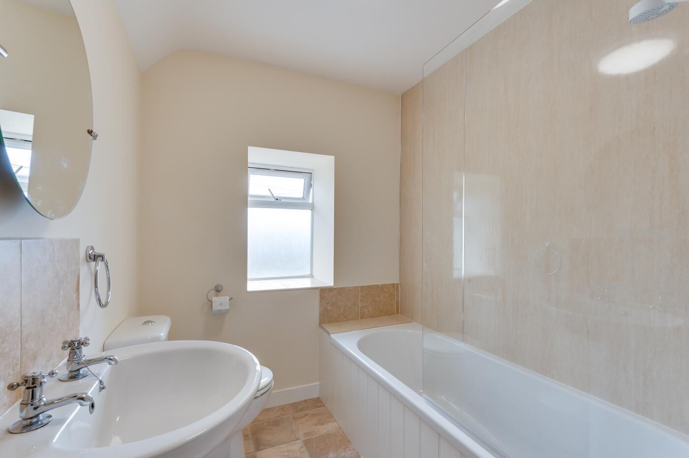 Een moderne badkamer met een bad, wastafel en toilet.