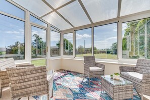 A sunroom with large windows, wicker furniture, and a patterned rug. - 2 Bed in Alnwick (oc-nb1986) (Howick)