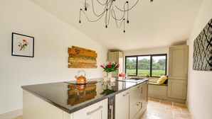 Una cocina moderna con una isla grande, una lámpara colgante y vistas al exterior.
