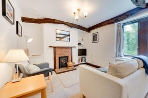 A cozy living room with a fireplace, a sofa, a table, and a TV. - 2 Bed in Bassenthwaite (oc-ld171) (Bassenthwaite)