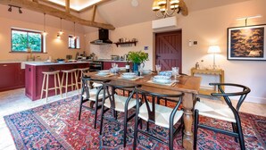 A spacious kitchen with a central island, wooden beams, and a dining area with a patterned rug. - 3 Bed in Ringsfield (oc-m33329) (Ringsfield)