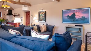 A living room with a sofa set, a painting, and a TV on the wall. - 3 Bed in Ringsfield (oc-m33329) (Ringsfield)