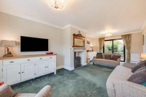 Ein Wohnzimmer mit Kamin, Fernseher und einer Couch.