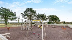 A playground with wooden structures, swings, and a covered play area. - 2 Bed in St. Merryn (oc-p00673) (Saint Merryn)