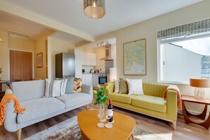 A living room with a sofa, a coffee table, a map on the wall, and a window. - 2 Bed in Kingswear (oc-sdems) (Dartmouth)
