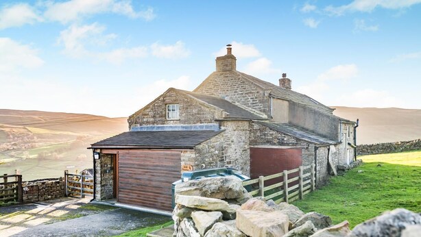 A stone farmhouse with a red garage door, a stone wall, and a grassy yard. - 4 Bed in Low Row (oc-h34097) (Crackpot)