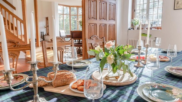 A dining area with a plaid tablecloth, wooden chairs, a wooden door, and a window with a view of trees. - 6 Bed in Englefield Green (oc-e34166) (Englefield Green)