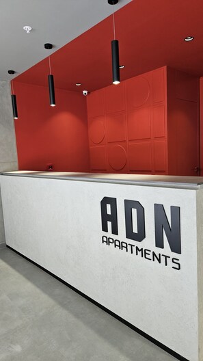 Mostrador de recepción con pared roja y mostrador blanco que muestra 