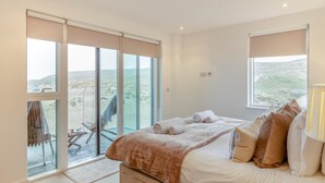 Une chambre à coucher avec un lit, une chaise, une fenêtre et une vue sur l’extérieur.