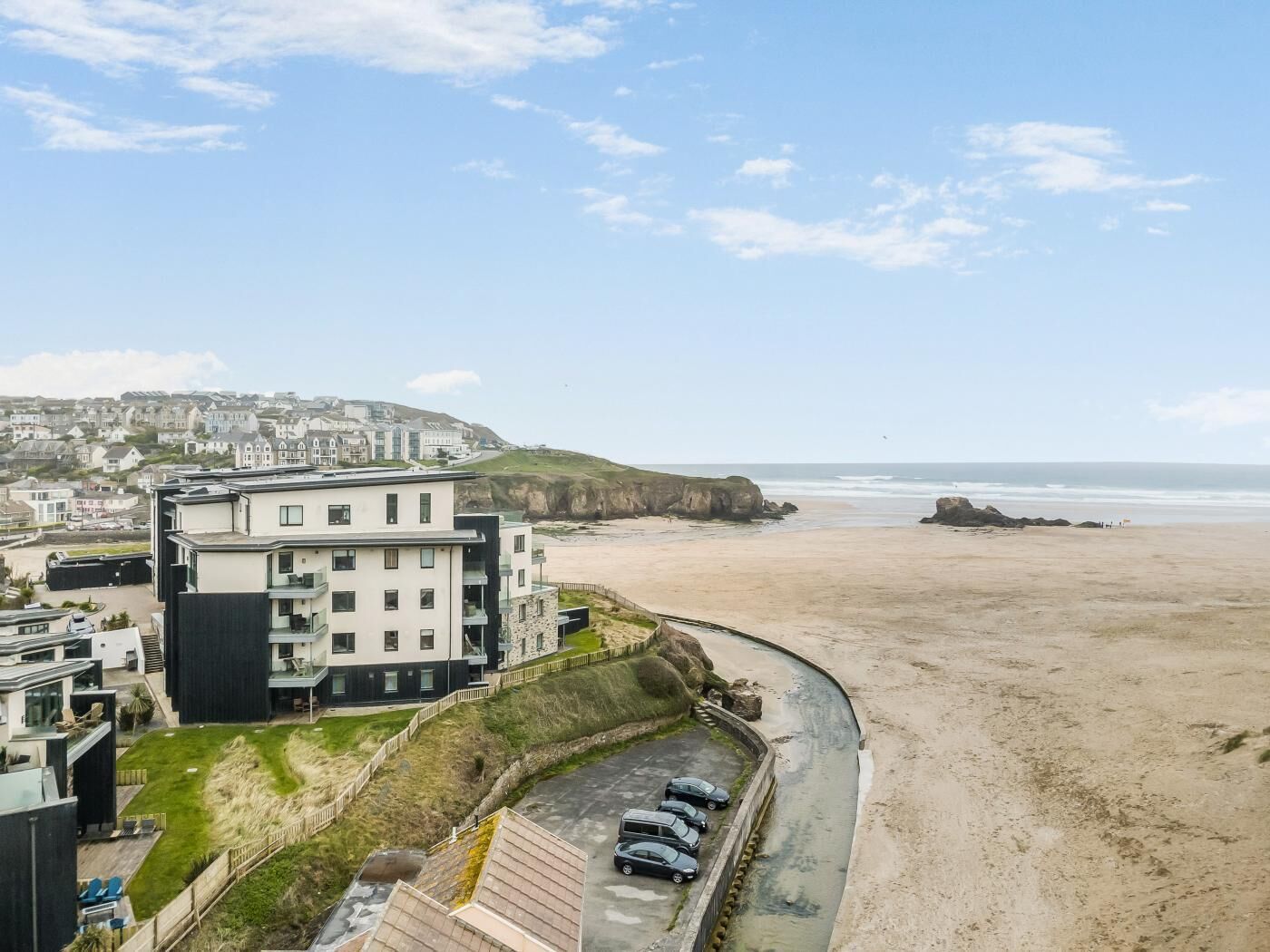 Ein Küstenhotel mit Blick auf den Strand und das Meer, das moderne Architektur und einen Parkplatz bietet.