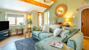 A cozy living room with a green sofa, a flat-screen TV, and a magazine on the floor. - 1 Bed in Slaithwaite (oc-c34249) (Ripponden)