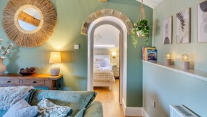 A cozy bedroom with a large mirror, a bedside table with a lamp, and a view into the adjacent room. - 1 Bed in Slaithwaite (oc-c34249) (Ripponden)