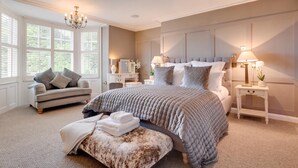 A bedroom with a large bed, a sofa, a nightstand, and a chandelier. - 5 Bed in Scalby (oc-sa871) (Scalby)