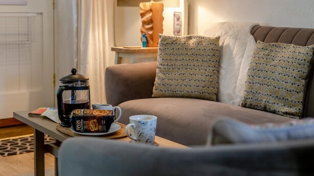 A cozy living room with a sofa, a coffee table, a lamp, and a decorative item on the wall. - 3 Bed in Eype (oc-e34183) (Eype)