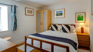 A bedroom with a bed, bedside tables, a wardrobe, and a window with curtains. - 3 Bed in Eype (oc-e34183) (Eype)