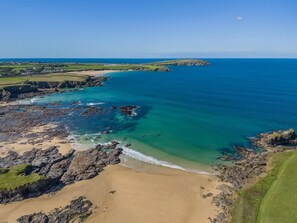 A coastal landscape with a sandy beach, rocky shoreline, and clear blue sea. - 3 Bed in Constantine Bay (oc-t34218) (Constantine Bay)