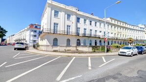 A multi-story building with a white facade, a balcony on the second floor, and a 'HIGHLANDER' sign. - 2 Bed in Scarborough (oc-s016) (Scarborough)