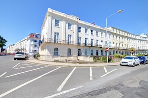 A multi-story building with a white facade, a balcony on the second floor, and a 'HIGHLANDER' sign. - 2 Bed in Scarborough (oc-s016) (Scarborough)