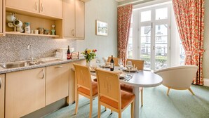 A kitchen with a dining area, a window with curtains, and a view outside. - 2 Bed in Scarborough (oc-s016) (Scarborough)