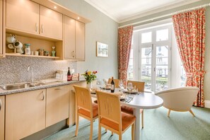 A kitchen with a dining area, a window with curtains, and a view outside. - 2 Bed in Scarborough (oc-s016) (Scarborough)