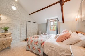 A bedroom with a bed, a dresser, a window, and a ceiling with exposed beams. - 3 Bed in Aberaeron (oc-bow315) (Bethania)