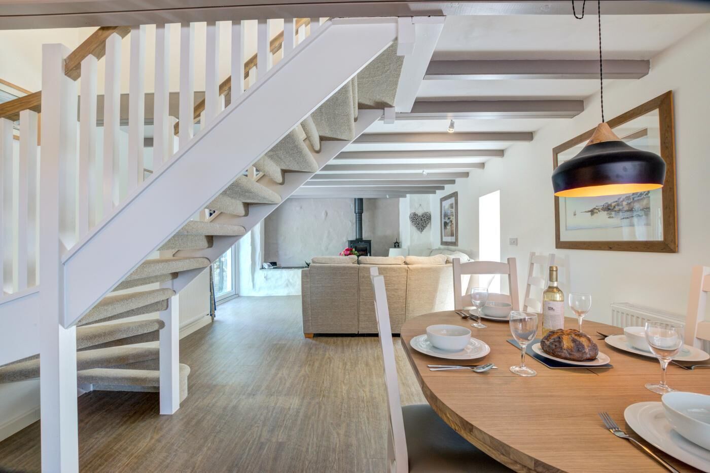 A modern interior with a staircase, dining area, and a living space.
