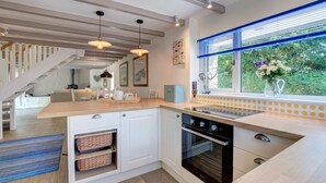 A modern kitchen with a built-in oven, a wooden countertop, and a window with blinds. - 3 Bed in Nr St. Keverne (oc-tremen) (Saint Keverne)