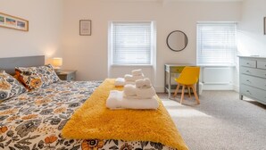 A hotel room with a bed, a desk, a chair, and a radiator. - 2 Bed in Tenby (oc-pw1031) (Tenby)