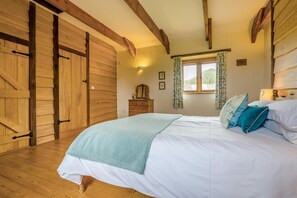 Ein Schlafzimmer mit Bett, Holzschrank und einem fenster mit Vorhängen.