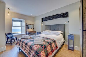 A bedroom with a large bed, a desk, and a window with a view. - 2 Bed in Barmouth (oc-bow52) (Llanaber)