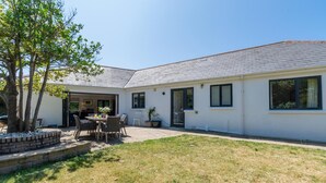 A single-story house with a patio, a dining area, and a garage. - 4 Bed in Trevone (oc-p00696) (Trevone)