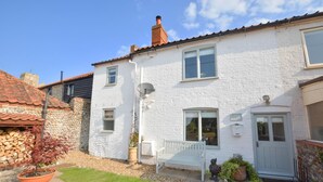 A white brick house with a tiled roof, a bench, and a door. - 2 Bed in Knapton (oc-1883) (Knapton)