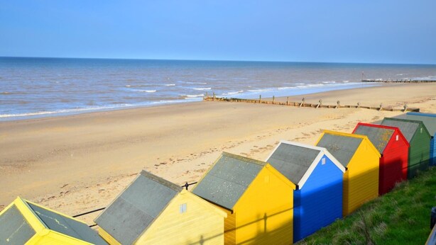 A beach with colorful beach huts in yellow, blue, and red. - 2 Bed in Knapton (oc-1883) (Knapton)