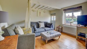 A living room with a sofa, ottoman, and a television. - 2 Bed in Knapton (oc-1883) (Knapton)