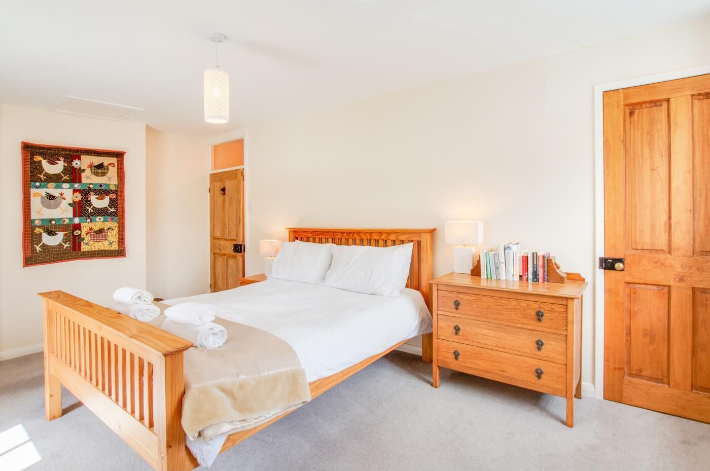 Une chambre à coucher bien rangée, avec un lit en bois, des tables de chevet et une armoire.