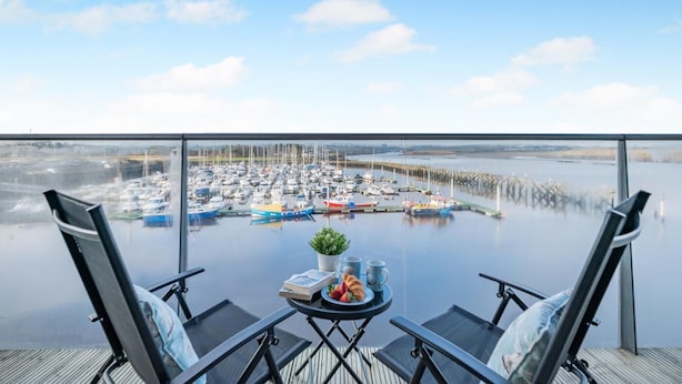 Een balkon met uitzicht op een jachthaven.