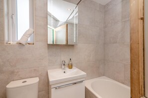 Une salle de bain avec des toilettes, un lavabo et une baignoire.