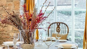 A dining table set with plates, glasses, and a centerpiece of dried flowers and branches. - 3 Bed in Trellech (oc-j34206) (Trelleck)