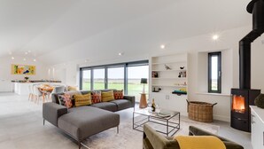 Un salon spacieux avec un canapé moderne, une table basse et une cheminée.