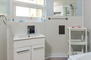 A bathroom with a sink, mirror, and shower. - 1 Bed in Tenby (oc-pw9282) (Tenby)
