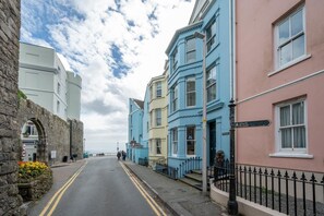 A street with buildings, a sign for 'Yayle Hospital,' and a stone wall on the left. - 1 Bed in Tenby (oc-pw9282) (Tenby)