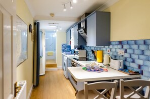 Cocina compacta con comedor, lavadora y microondas.