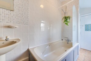 A bathroom with a sink, bathtub, and shower. - 4 Bed in Tenby (oc-pw9281) (Tenby)