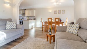 A modern living room with two sofas, a coffee table, and a dining area with wooden chairs and a table. - 3 Bed in Lockton (oc-y119) (Lockton)