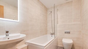 Ein modernes Badezimmer mit Waschbecken, Badewanne und Toilette.